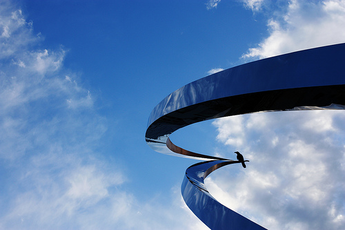 Blue sky, white clouds and black bird